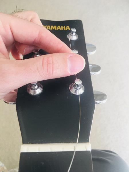 Insert the string on the tuning peg